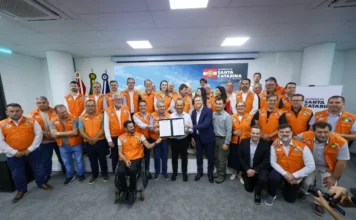 Sul de SC recebe R$ 102 milhões em investimento da Defesa Civil Governador Jorginho Mello e autoridades em coletes laranja da Defesa Civil posam segurando documentos, celebrando investimento de R$ 102 milhões.