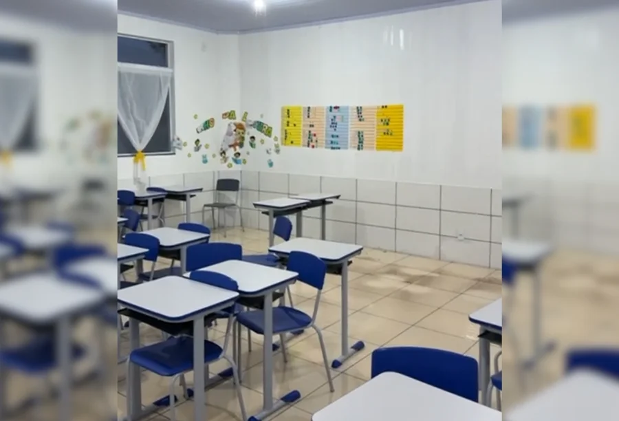 Temporal atinge Balneário Gaivota e deixa casas destelhadas Interior de uma sala de aula de escola em Balneário Gaivota após ser atingida por temporal. As carteiras e cadeiras azuis e brancas estão dispostas em fileiras sobre o piso manchado de água barrenta e suja, que alagou a sala. As paredes são brancas e há sinais de umidade ou sujeira na parte inferior.