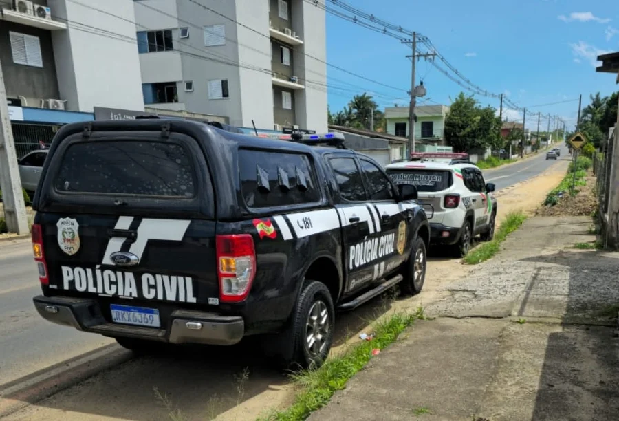 Viatura da Polícia Civil (caminhonete preta) e viatura da Polícia Militar (carro branco) estacionadas em uma rua de Turvo durante operação policial.