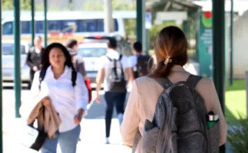 Unesc é 1ª em Ensino entre as não públicas no ranking THE Estudantes caminhando no campus da Unesc com mochilas, em plano desfocado, representando o ambiente universitário.
