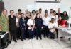 Grupo de alunos com deficiência e professores da Unesc posam para foto em uma sala de aula de informática após a formatura do curso "Office para Todos".