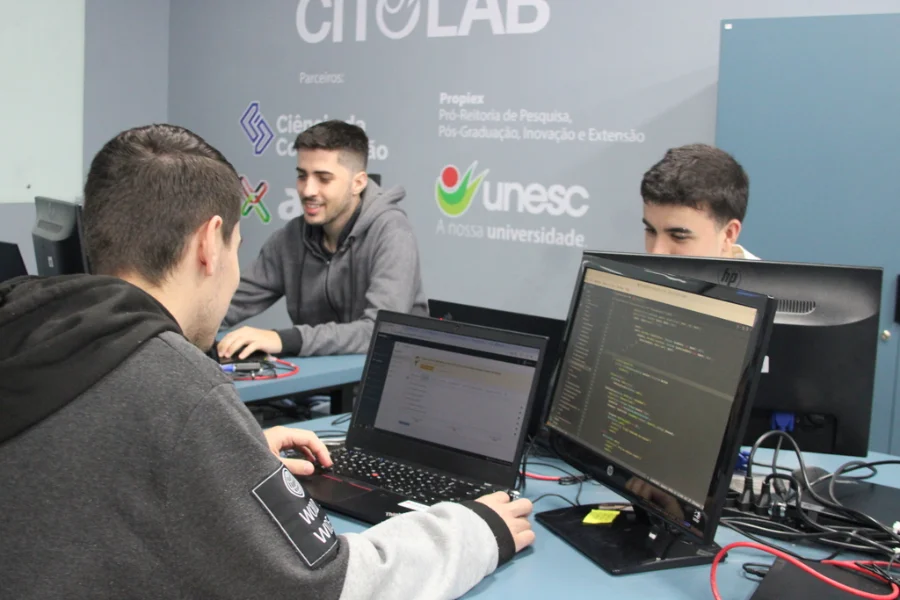 Curso de Engenharia de Software na Unesc em Criciúma. Estudantes em laboratório de informática. Santa Catarina projeta quase 100 mil novas vagas em TI até 2027.