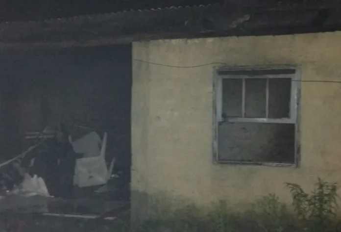 Urussanga Incêndio atinge edícula no bairro Bom Jesus "Registro noturno de edícula abandonada e atingida por incêndio em Urussanga. A imagem mostra a estrutura de alvenaria com entulhos visíveis no interior através de uma abertura na parede."