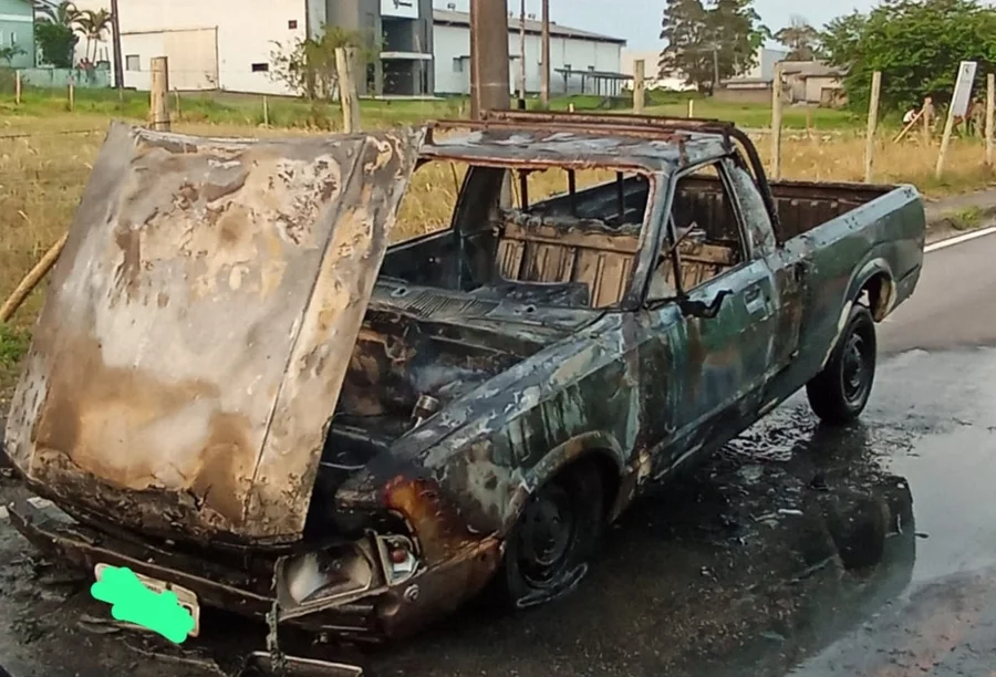 Picape Ford Pampa totalmente destruída pelo fogo na lateral de uma estrada, com a lataria queimada e capô aberto, em Santa Rosa do Sul.