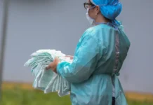 Vírus K: Variante da gripe no Brasil não gera alerta, diz SBIm Profissional de saúde manuseia máscaras de proteção, simbolizando as medidas de prevenção contra variantes da gripe, como o recém-identificado vírus K