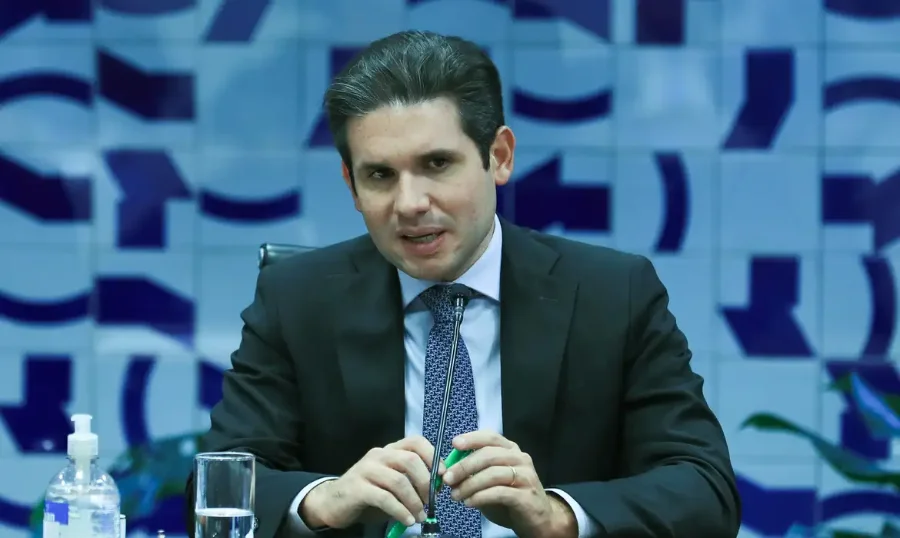 Votação de PEC da Segurança na comissão especial será quinta O presidente da Câmara, Hugo Motta, de terno e gravata, sentado em uma mesa, falando em um microfone em uma reunião ou entrevista sobre a PEC da Segurança Pública.