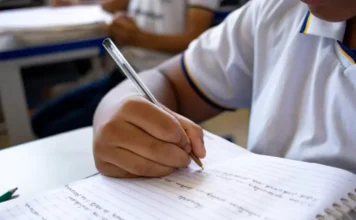 Alesc aprova pacote de leis para proteção escolar em SC Estudante em sala de aula escrevendo em um caderno, ilustrando o ambiente escolar impactado pelas novas leis de proteção e cidadania aprovadas pela Alesc.