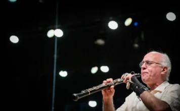 Alex Klein recebe título de Cidadão Catarinense na segunda Maestro Alex Klein tocando oboé no palco com iluminação ao fundo; o músico será homenageado com o Título de Cidadão Catarinense.