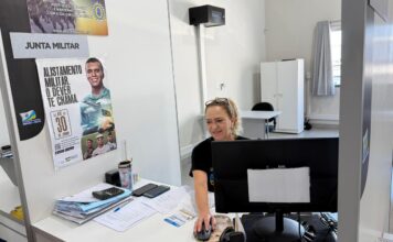 Alistamento militar: Prazo aberto em Balneário Arroio do Silva Atendimento na Junta de Serviço Militar de Balneário Arroio do Silva, com cartazes ao fundo informando o prazo final de 30 de junho para o alistamento militar.