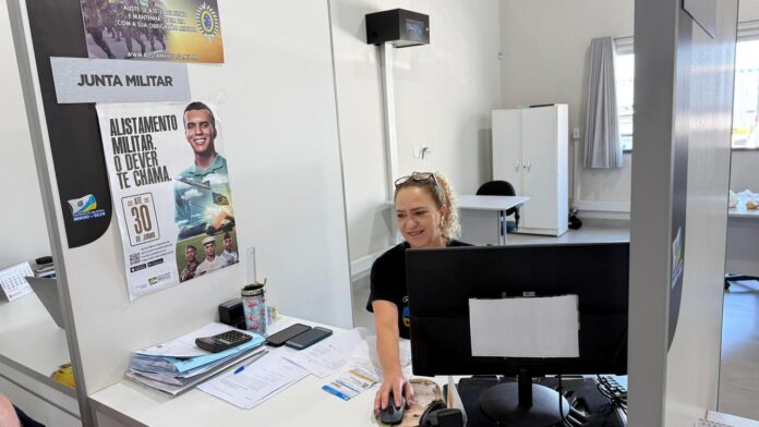 Alistamento militar Prazo aberto em Balneário Arroio do Silva Atendimento na Junta de Serviço Militar de Balneário Arroio do Silva, com cartazes ao fundo informando o prazo final de 30 de junho para o alistamento militar.