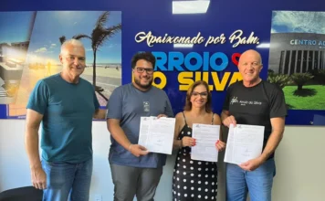 Arroio do Silva autoriza pavimentação na Lagoinha Prefeito Evandro Scaini e a vereadora Maria Alice Luciano, juntamente com outros presentes, seguram a ordem de serviço assinada para as obras de pavimentação e drenagem na Zona Sul de Balneário Arroio do Silva.