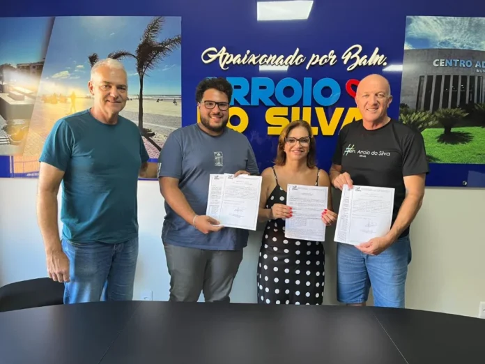 Arroio do Silva autoriza pavimentação na Lagoinha Prefeito Evandro Scaini e a vereadora Maria Alice Luciano, juntamente com outros presentes, seguram a ordem de serviço assinada para as obras de pavimentação e drenagem na Zona Sul de Balneário Arroio do Silva.