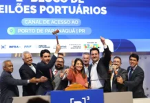 B3 bate recorde com R$ 243,8 bi em investimentos no ano Grupo de autoridades e executivos celebra no palco da B3 durante o leilão do canal de acesso ao Porto de Paranaguá. No centro da imagem, um homem ergue o martelo de madeira (gavel) simbolizando a conclusão do lance, enquanto outros sorriem e fazem sinal de "positivo". Ao fundo, um grande painel azul exibe o texto "2º Bloco de Leilões Portuários - Canal de Acesso ao Porto de Paranaguá | PR", acompanhado de logotipos institucionais do Governo Federal, Antaq e B3.