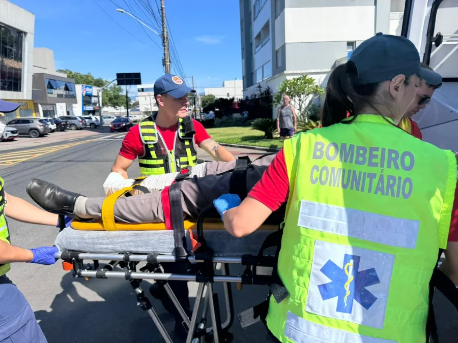 Bombeiros militares e comunitários do 4º Batalhão de Criciúma realizam o transporte de um paciente em uma maca durante um atendimento pré-hospitalar em via pública. A imagem ilustra a principal demanda da corporação em 2025, que concentrou a maioria dos chamados na região sul de Santa Catarina.