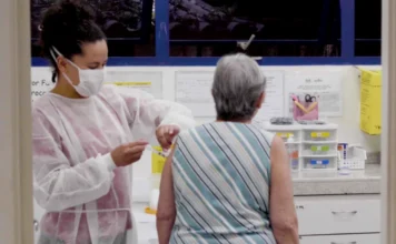 Butantan testa nova vacina da gripe para idosos Profissional de saúde aplica vacina contra a gripe em uma mulher idosa em um ambiente clínico, ilustrando o público-alvo do novo estudo do Instituto Butantan.