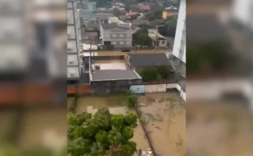 Chuva gera alagamentos pontuais em Criciúma neste sábado Vista superior de área residencial em Criciúma com ruas e terrenos alagados pela água da chuva, ilustrando os pontos de alagamento monitorados pela Defesa Civil.