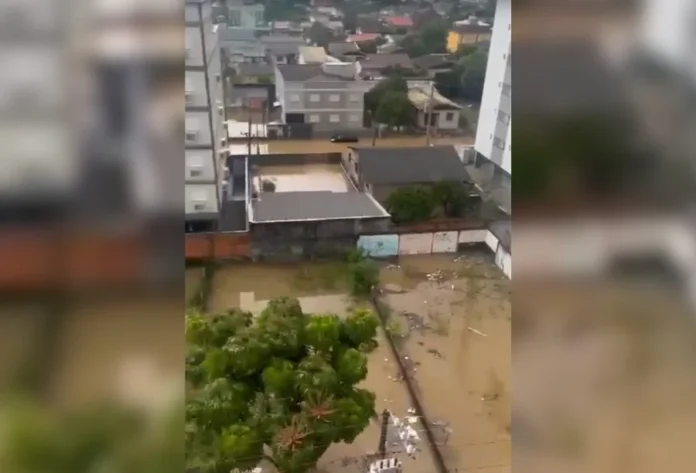 Chuva gera alagamentos pontuais em Criciúma neste sábado Vista superior de área residencial em Criciúma com ruas e terrenos alagados pela água da chuva, ilustrando os pontos de alagamento monitorados pela Defesa Civil.