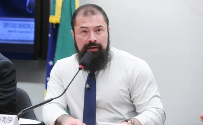 Comissão aprova defesa jurídica gratuita para policiais "Deputado Delegado Paulo Bilynskyj (PL-SP), relator do projeto, fala ao microfone durante sessão da Comissão de Segurança Pública da Câmara."
