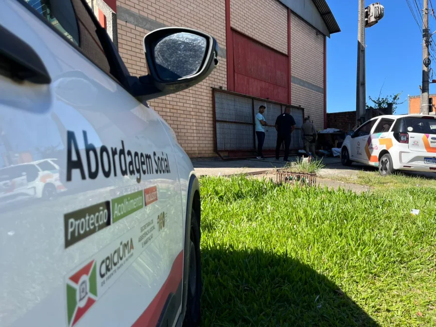 Fotografia em ângulo lateral de um veículo oficial da Prefeitura de Criciúma. Em destaque, no primeiro plano, está o adesivo na lateral do carro com os dizeres 