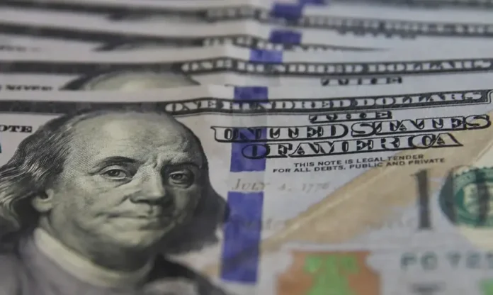 Dólar cai a R$ 5,36 e Bolsa recupera os 163 mil pontos Close de notas de cem dólares americanos em destaque, focando na efígie de Benjamin Franklin; moeda encerrou a sexta-feira em queda, cotada a R$ 5,36.
