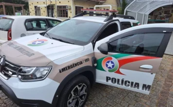 Dupla é presa após furto e atropelamento grave no Sul Foto de uma viatura da Polícia Militar de Santa Catarina, modelo Renault Duster, estacionada com a porta do motorista aberta em uma rua de paralelepípedos. O veículo ilustra a atuação da corporação responsável pela prisão dos envolvidos na sequência de crimes no Sul do estado.