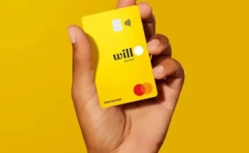 Entenda a liquidação do Will Bank e o impacto no FGC Mão segurando o cartão de crédito amarelo do Will Bank com logotipo da Mastercard, instituição financeira que teve sua liquidação extrajudicial decretada pelo Banco Central do Brasil.