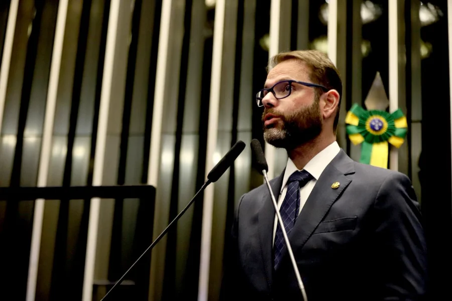 O senador Jorge Seif durante pronunciamento no Senado Federal sobre o pedido de prisão domiciliar humanitária para Jair Bolsonaro. O parlamentar aparece de perfil, falando seriamente em um dos púlpitos da casa.