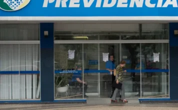 INSS fecha agências para manutenção de sistemas da Dataprev Entrada de uma agência do INSS com aviso na porta sobre a suspensão temporária do atendimento presencial para manutenção de sistemas.