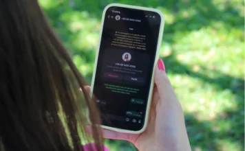 IPTU 2026 em Criciúma: saiba como pagar pelo WhatsApp Smartphone exibe a interface de mensagens com a assistente virtual Cris, da Prefeitura de Criciúma, mostrando a solicitação da guia do IPTU 2026 através do número (48) 3431-0150