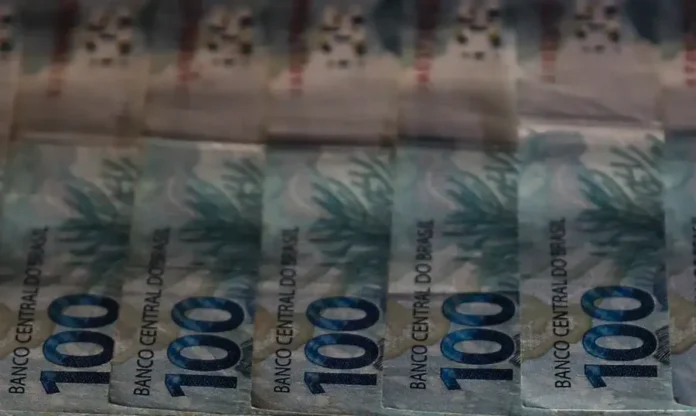 IVA Dual Novo sistema de impostos entra em vigor Notas de 100 reais em destaque. Reforma tributária brasileira entra em vigor em 2026 com o IVA Dual (CBS e IBS); transição gradual começa com alíquota de 1% e novas regras para emissão de notas fiscais.