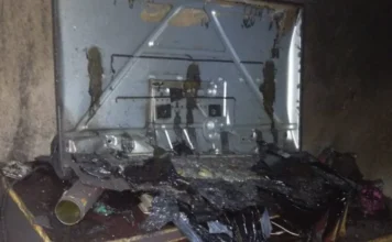 Incêndio atinge kitnet no bairro Pinheirinho em Criciúma Foto do interior de uma kitnet em Criciúma após incêndio. Sobre um móvel de madeira queimado, há uma televisão e um ventilador derretidos pelo calor. As paredes estão cobertas de fuligem preta e o chão apresenta destroços e marcas de fogo.