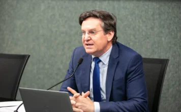 Jair Miotto reforça pré-candidatura e pautas de valores Fotografia do deputado Jair Miotto (União Brasil) em primeiro plano, utilizando um notebook e falando ao microfone. O parlamentar discute pautas conservadoras e ações legislativas na Assembleia Legislativa de Santa Catarina.