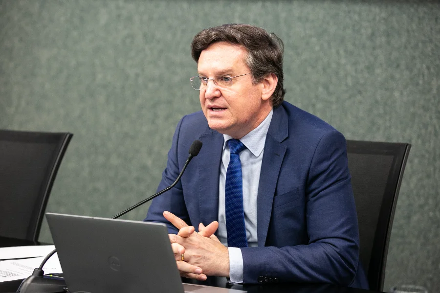 Jair Miotto reforça pré-candidatura e pautas de valores Fotografia do deputado Jair Miotto (União Brasil) em primeiro plano, utilizando um notebook e falando ao microfone. O parlamentar discute pautas conservadoras e ações legislativas na Assembleia Legislativa de Santa Catarina.