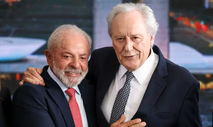 Lewandowski pede demissão do Ministério da Justiça O presidente Luiz Inácio Lula da Silva, à esquerda, sorri e abraça lateralmente o ministro Ricardo Lewandowski, à direita, que também sorri levemente. Ambos vestem terno e gravata e posam para a foto em um ambiente de evento.