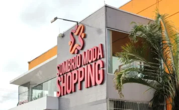 Liquida Verão: Sombrio Moda Shopping tem descontos de 50% Fachada externa do Sombrio Moda Shopping, com letreiro em vermelho e logomarca, em um prédio de arquitetura moderna e palmeira na lateral direita.