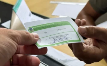 Morro da Fumaça inicia emissão de carteirinhas escolares Mãos aparecem em close segurando a carteirinha de transporte escolar da Prefeitura Municipal de Morro da Fumaça, um cartão branco com detalhes em verde. O documento, cuja confecção para 2026 é tema da matéria, é obrigatório para o uso do transporte gratuito por estudantes no município.