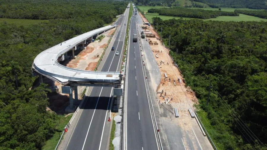 Vista aérea das obras de construção do novo viaduto no km 246 da BR-101 Sul, em Paulo Lopes (SC), mostrando a estrutura de concreto sobre a rodovia onde a ViaCosteira realiza a operação de içamento de vigas.