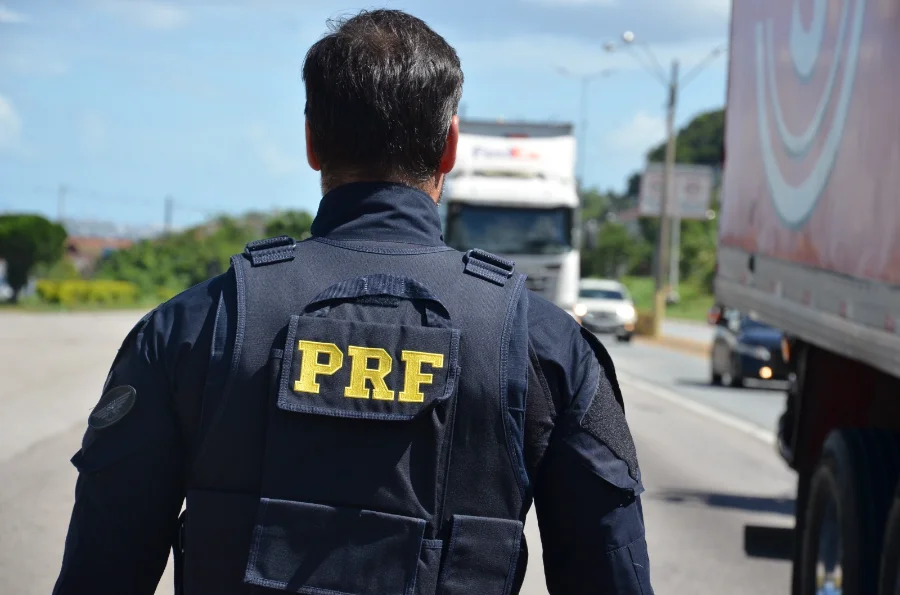 Agente da PRF fiscaliza rodovia em Santa Catarina. Balanço da Operação Ano Novo 2026 indica redução de mortes, apesar do aumento de 13% no total de acidentes e flagrantes de excesso de velocidade.