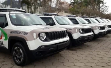 PM recupera R$ 17,4 mil e prende suspeitos de roubo em SC Uma fileira de viaturas policiais modelo Jeep Renegade, da cor branca com faixas marrons e o brasão da Polícia Militar, estacionadas alinhadas em um pátio pavimentado durante o dia. Ao fundo, veem-se árvores e prédios residenciais. A imagem ilustra a presença da corporação responsável pela ocorrência.
