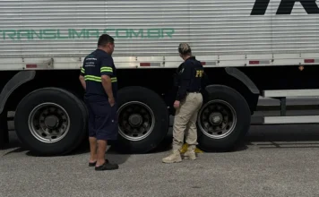 PRF inicia operação Freio Seguro em SC nesta quinta Agente da PRF inspeciona as rodas e o sistema de freios de um caminhão branco ao lado do motorista durante a Operação Freio Seguro em Santa Catarina.