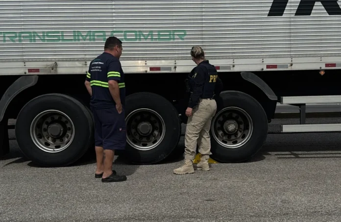 PRF inicia operação Freio Seguro em SC nesta quinta Agente da PRF inspeciona as rodas e o sistema de freios de um caminhão branco ao lado do motorista durante a Operação Freio Seguro em Santa Catarina.