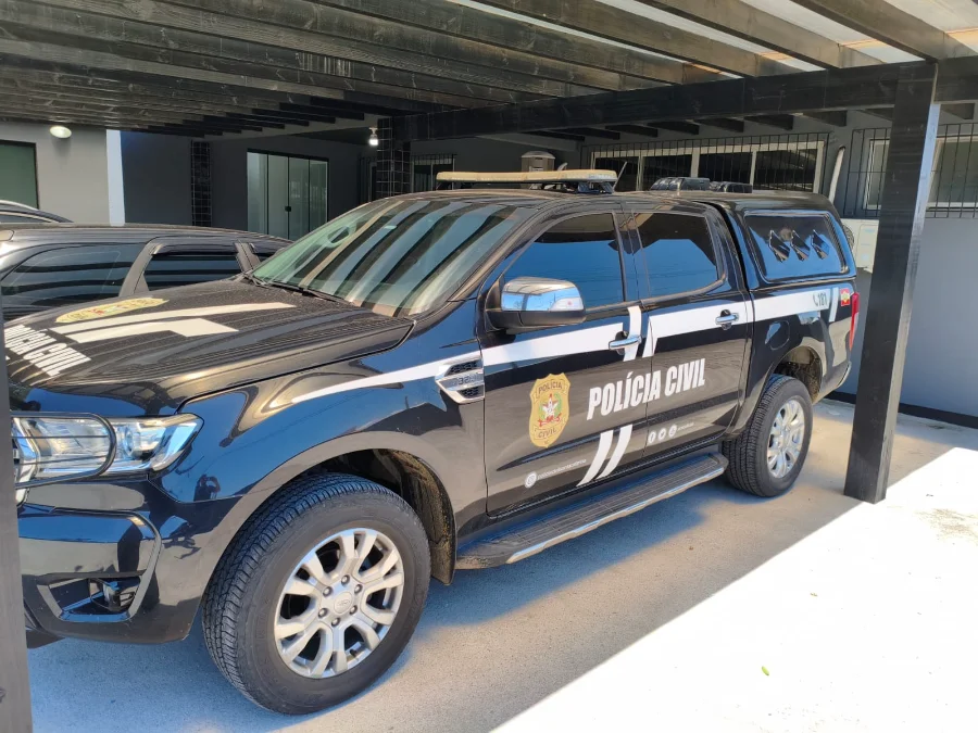 Policial civil salva homem em Araranguá durante transporte Viatura oficial da Polícia Civil de Santa Catarina, modelo Ford Ranger na cor preta, com identificação ostensiva em branco e o brasão da instituição na porta lateral. O veículo está estacionado sob uma estrutura de madeira, representando a frota utilizada em operações como a Operação Verão, mencionada na reportagem sobre o salvamento em Araranguá.