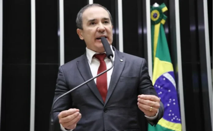Projeto de lei prevê folga remunerada no aniversário O deputado federal Duda Ramos (MDB-RR), autor do Projeto de Lei 886/25 que propõe folga remunerada no aniversário do trabalhador, discursa ao microfone no plenário da Câmara dos Deputados, com a bandeira do Brasil ao fundo.