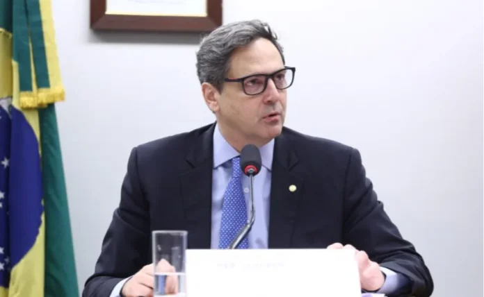 Projeto na Câmara permite que Ltdas emitam debêntures Fotografia do deputado Luiz Philippe de Orleans e Bragança sentado à mesa em uma comissão. Ele é um homem de pele clara, cabelos grisalhos curtos e usa óculos de grau, terno escuro e gravata azul com pontos brancos. Ao fundo, vê-se a bandeira do Brasil. Ilustra o projeto que permite a empresas Ltda emitirem debêntures.