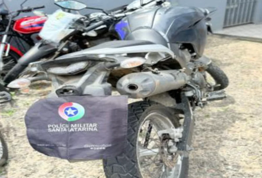 Traseira da motocicleta Yamaha Lander recuperada pela Polícia Militar de Santa Catarina em Araranguá, com uma bolsa da corporação cobrindo a placa.