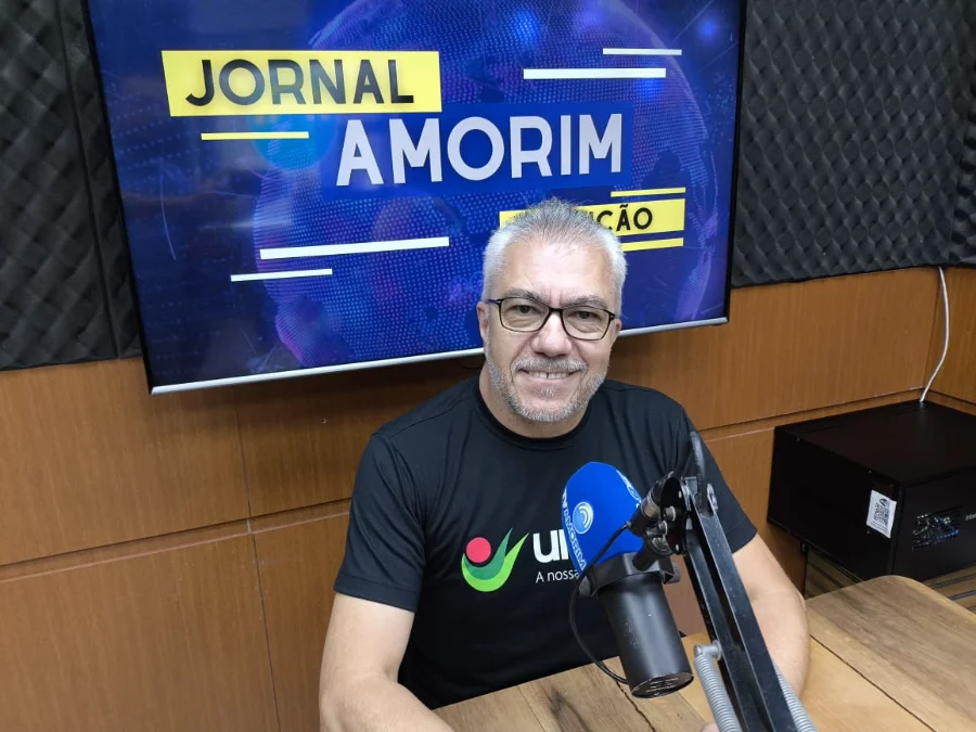 Unesc Araranguá abre vagas para novos cursos superiores O diretor da Unesc Araranguá, Dorvanil Vieira, aparece sentado em um estúdio de rádio profissional. Ele é um homem de pele clara, cabelos grisalhos e usa óculos de grau. Veste uma camiseta preta com o logotipo da Unesc. À sua frente, há um microfone com a marca da rádio 102.9 Amorim FM. Ao fundo, uma tela de televisão exibe a identidade visual do