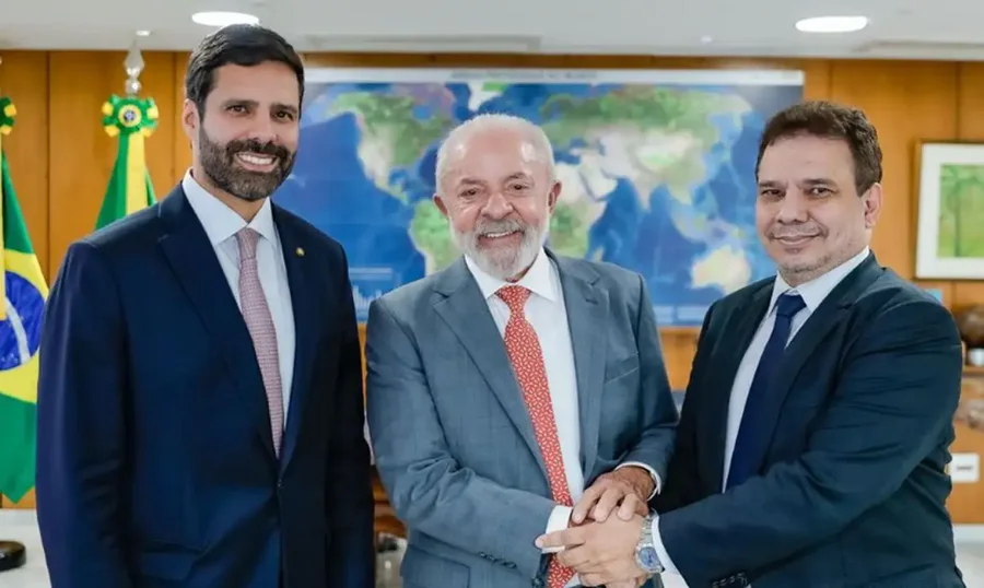 O presidente Luiz Inácio Lula da Silva (centro) cumprimenta Wellington César Lima e Silva (direita), o novo ministro da Justiça e Segurança Pública, na presença de outro homem (esquerda), em encontro que oficializou a nomeação noticiada na matéria.
