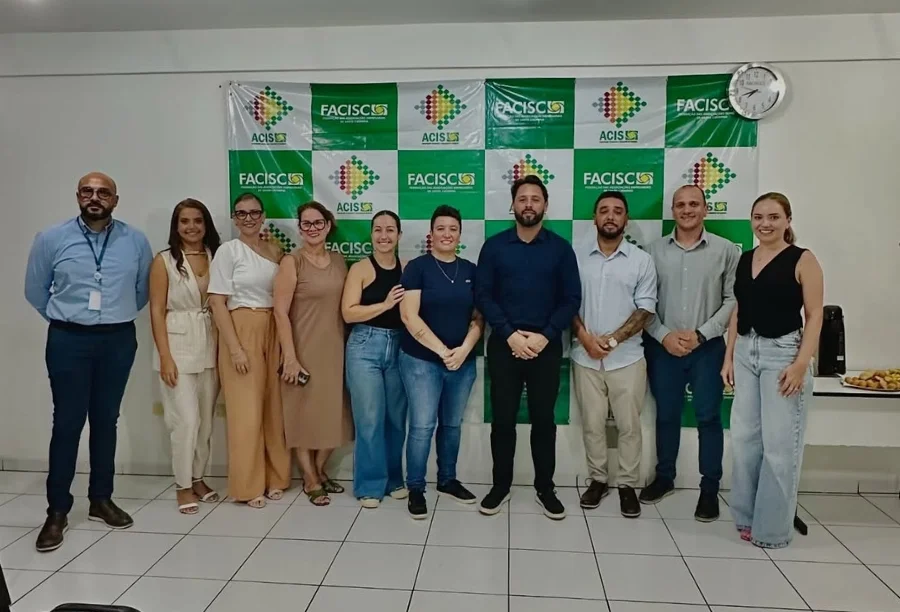 Membros da nova diretoria da ACIS, eleita para o biênio 2026/2027, posam juntos em frente a um banner da entidade.