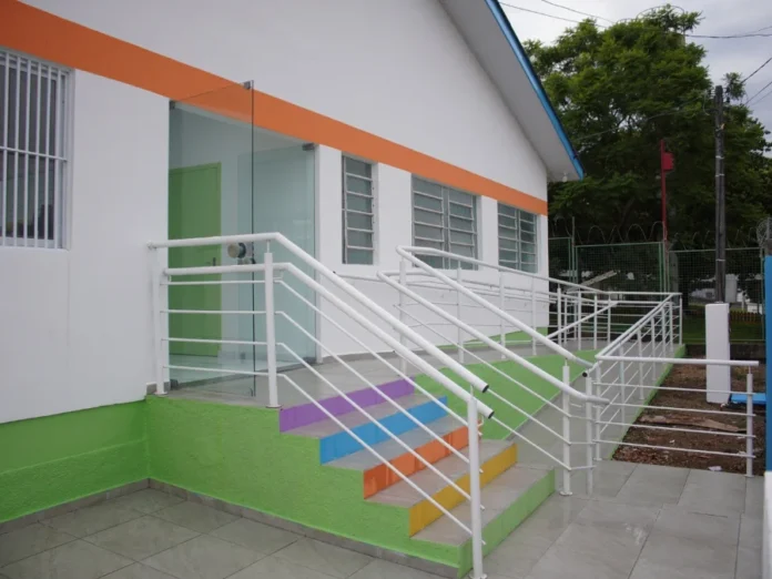 Afasc reforma CEIs e amplia segurança em Criciúma Entrada principal de unidade escolar revitalizada pela Afasc. A imagem destaca a nova pintura, a estrutura de acessibilidade e o acabamento moderno, refletindo a padronização e segurança das obras realizadas em 2026.