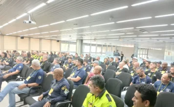 Araranguá participa de encontro estadual de trânsito Fotografia em ângulo aberto de um auditório repleto de agentes de trânsito uniformizados, sentados em poltronas pretas, acompanhando as atividades do encontro estadual em Criciúma.